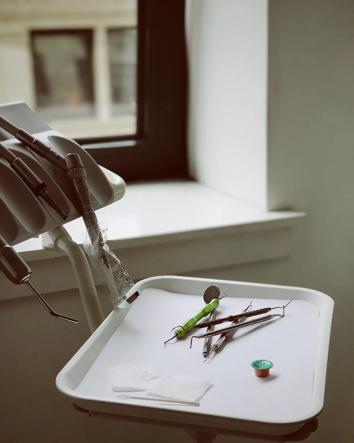 Dental tools laid out on a tray in a bright exam room