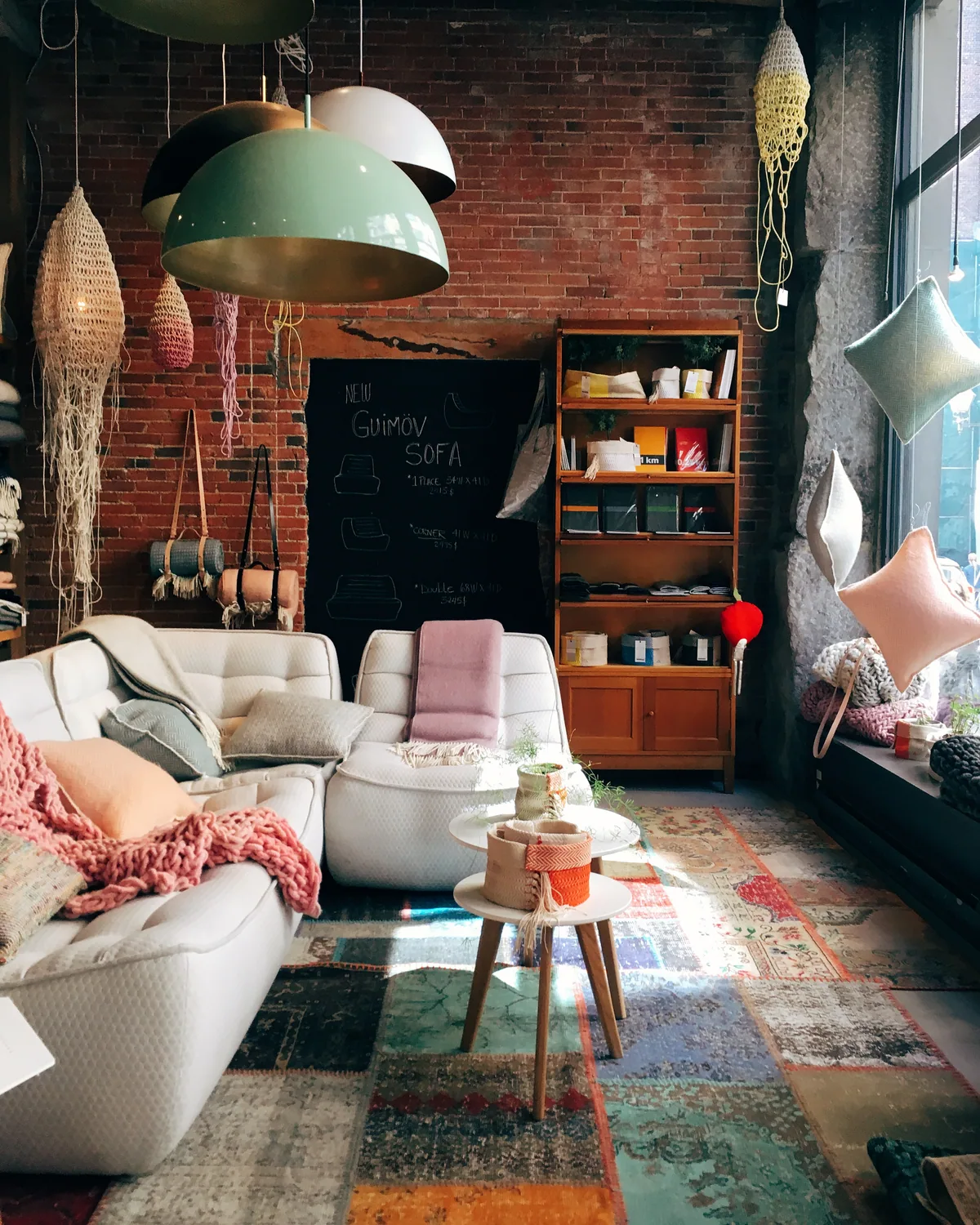 A furnished loft living room with an exposed brick wall